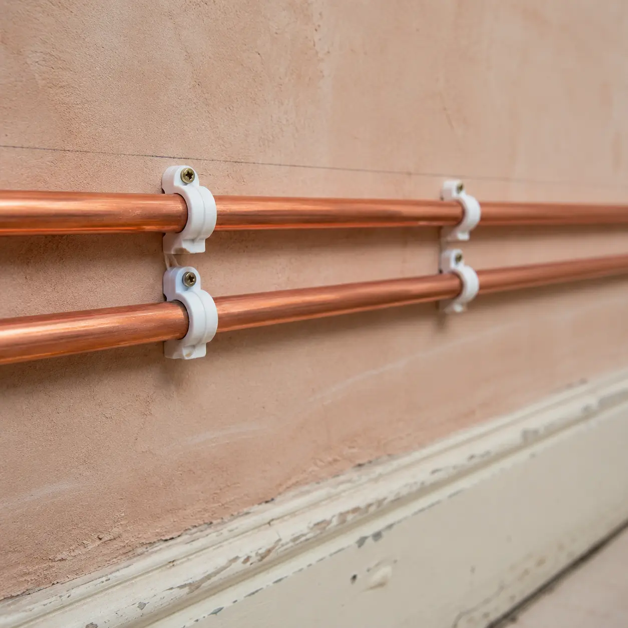 Plumber installing a heat pump hot-water cylinder in an Irish home